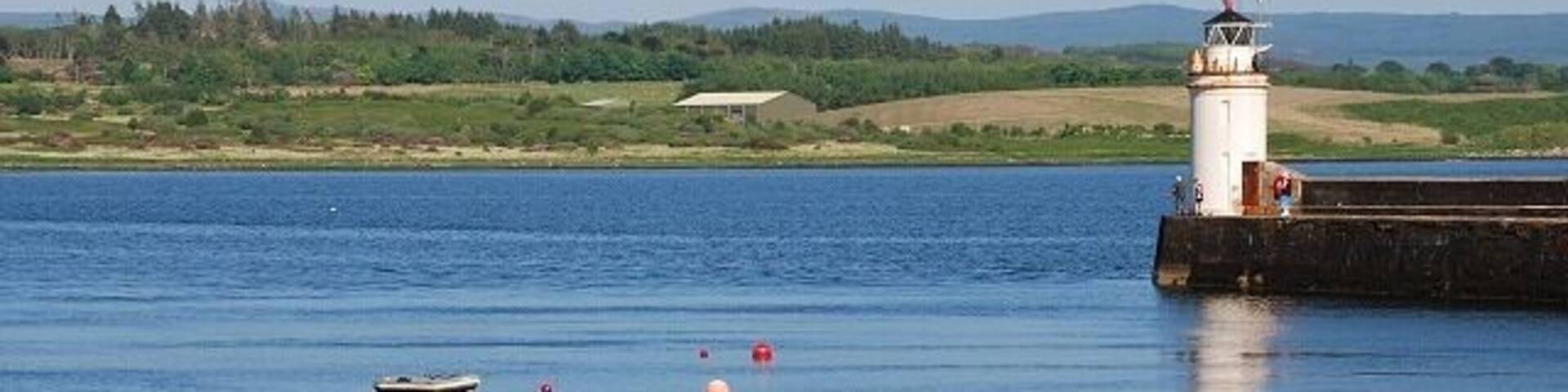 Ardrishaig pier and light It's a beautiful sunny afternoon with a good breeze, so all the mooring buoys are empty - everyone's out enjoying the sailing. Lingerton landfill on the other side of Loch Gilp.