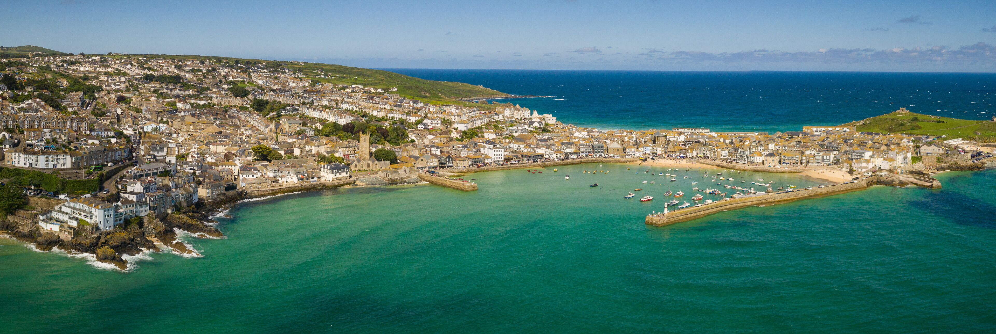 A coastal town with a harbor, boats, and a prominent church.