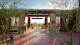 The Arizona-Sonora Desert Museum entrance with a wooden archway, metal gates, and a cactus sculpture.