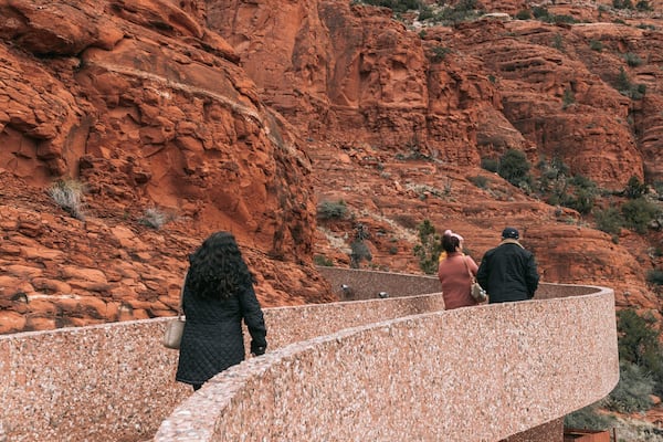 Chapel of the Holy Cross featuring a gorge or canyon as well as a small group of people