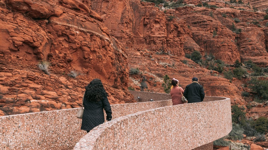 Chapel of the Holy Cross featuring a gorge or canyon as well as a small group of people