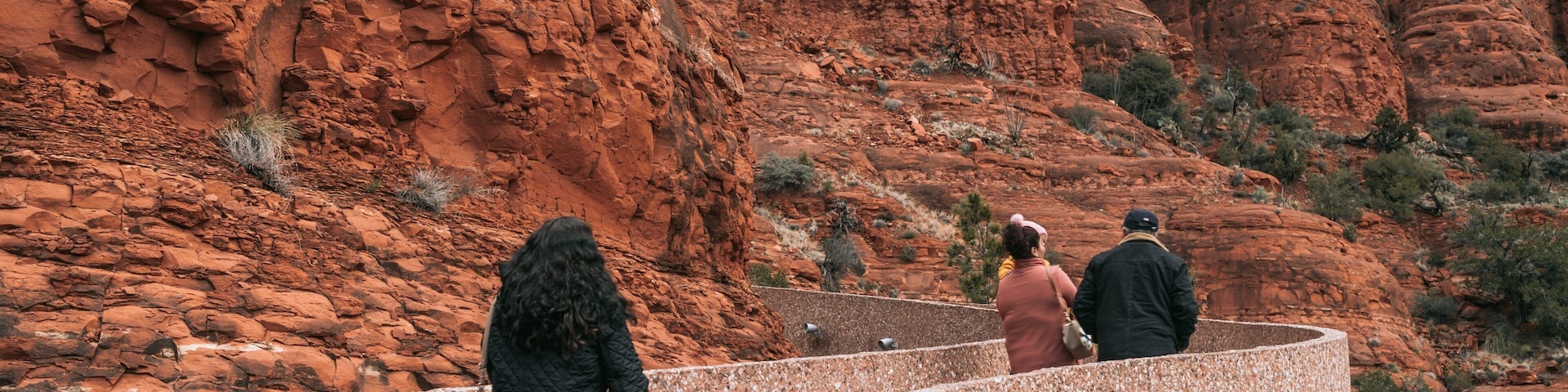 Chapel of the Holy Cross featuring a gorge or canyon as well as a small group of people