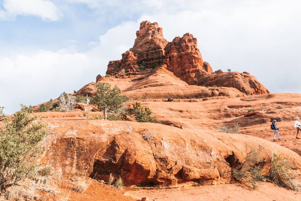 A red rock formation with hikers.