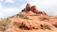 A red rock formation with hikers.