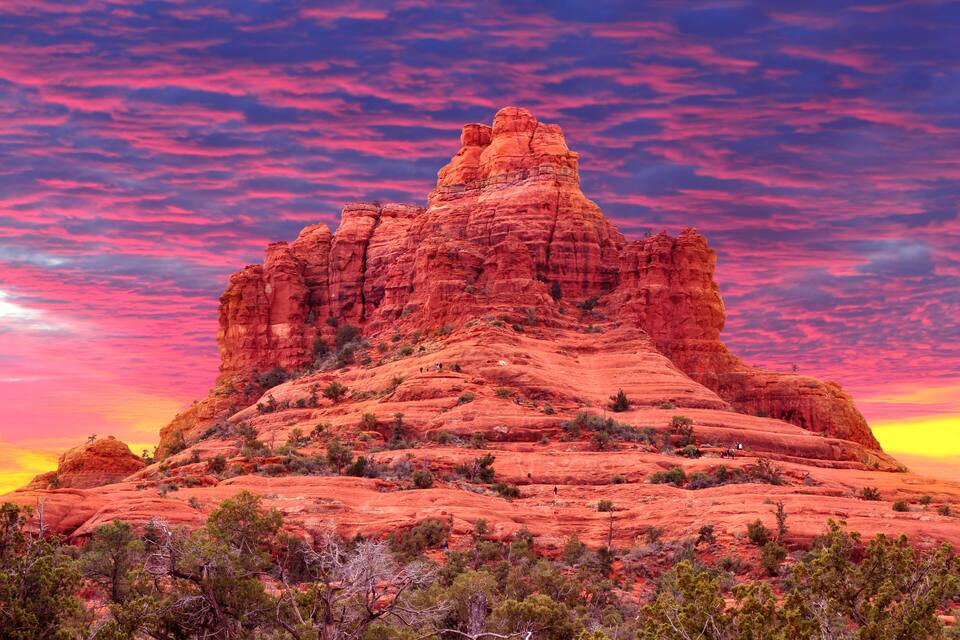 Eine rote Felsformation unter blauem Himmel.