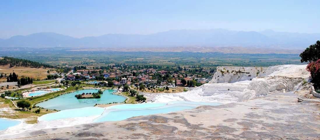 A landscape with terraced pools and a town in the valley.