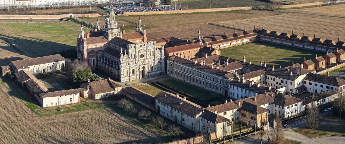 An aerial view of a historic complex with a large church, a courtyard, and surrounding buildings.