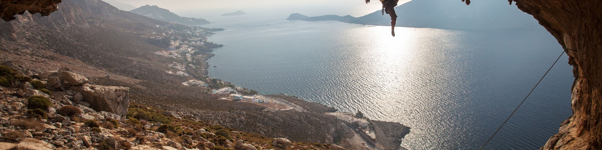 Family rock climber against picturesque view of Telendos Island at sunset. Kalymnos Island, Greece