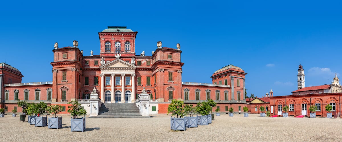 A large red brick building with a central dome and multiple towers.