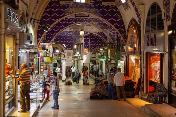 Un marché animé, avec des étals aux couleurs vives et un plafond orné de motifs.