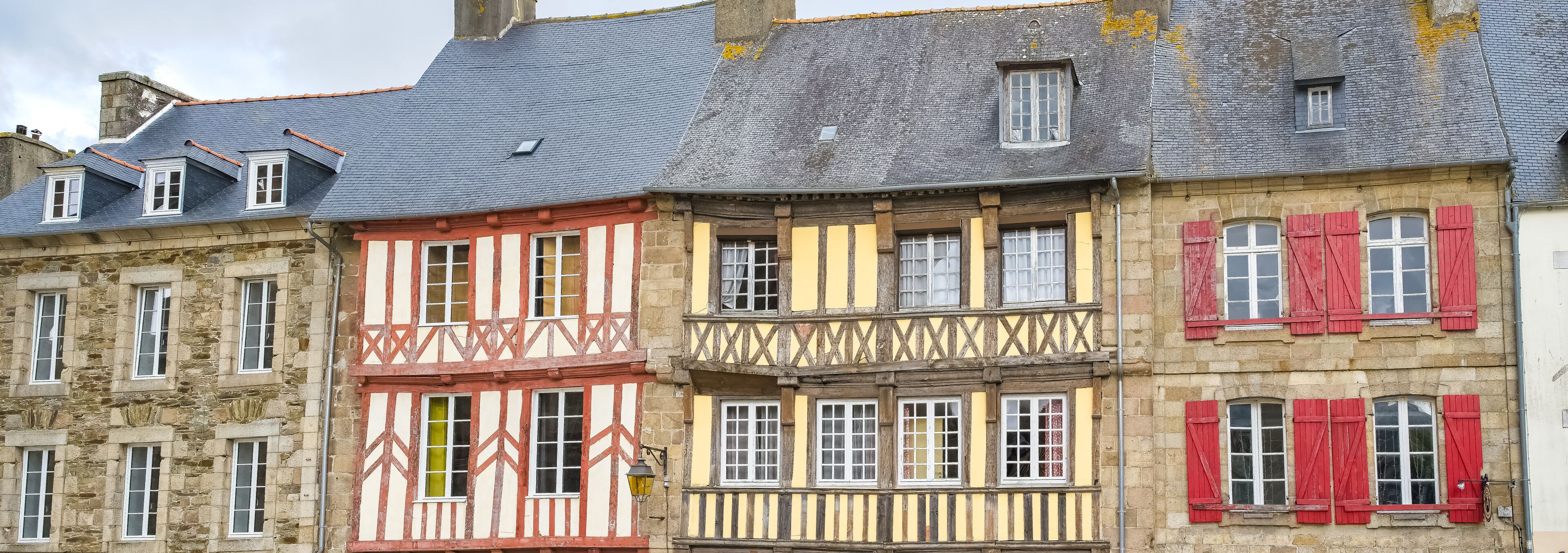 A row of half-timbered buildings with red and yellow facades.