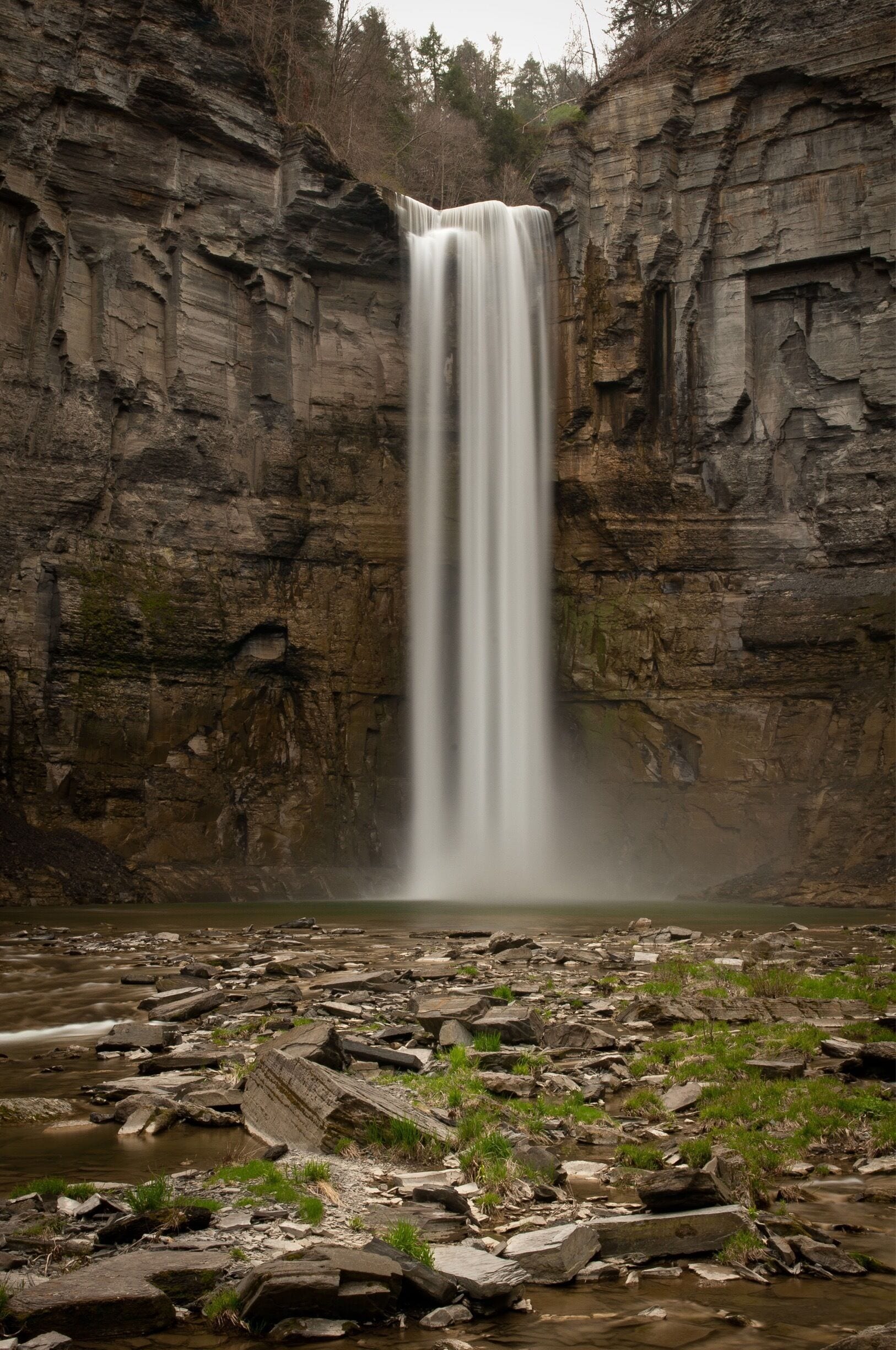 A waterfall cascading down a rocky cliff into a river.