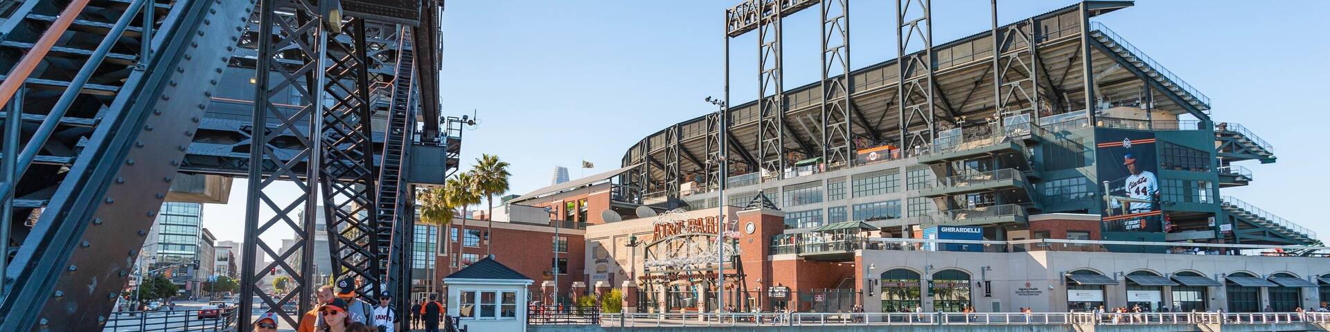 Oracle Park featuring a bay or harbor and street scenes as well as a small group of people