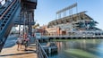Oracle Park featuring a bay or harbor and street scenes as well as a small group of people