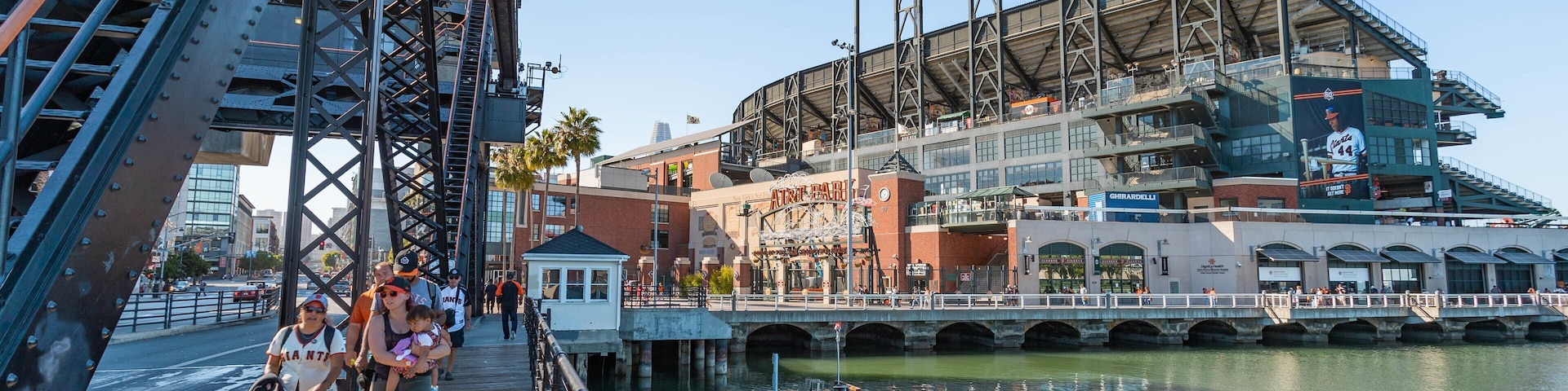 Oracle Park featuring a bay or harbor and street scenes as well as a small group of people
