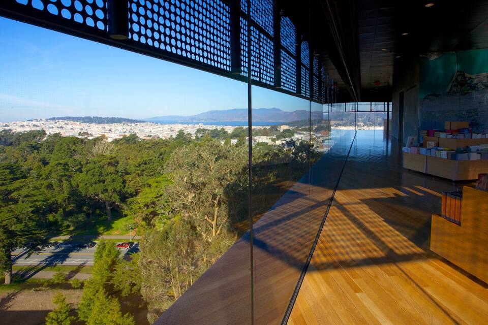 A modern interior with a large glass window overlooking a cityscape and greenery.