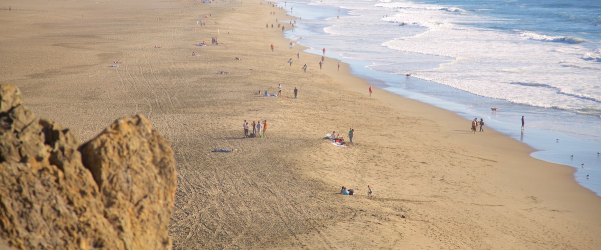 Ocean Beach which includes a beach and landscape views as well as a large group of people