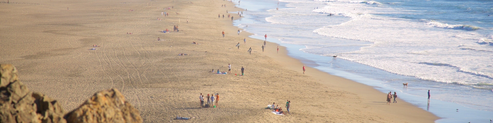 Ocean Beach which includes a beach and landscape views as well as a large group of people