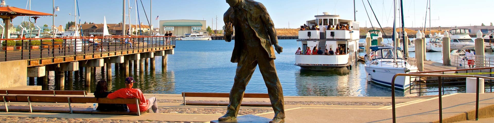 Jack London Square which includes a bay or harbor and a statue or sculpture