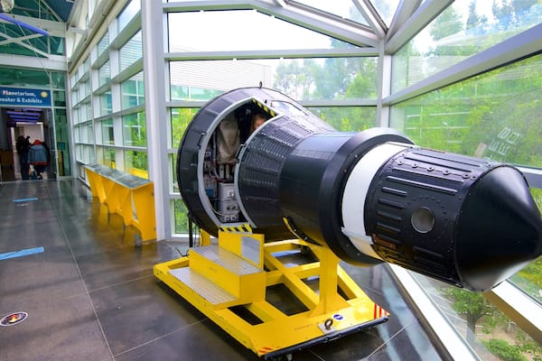 A large telescope inside a building with glass walls.