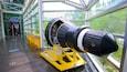 A large telescope inside a building with glass walls.