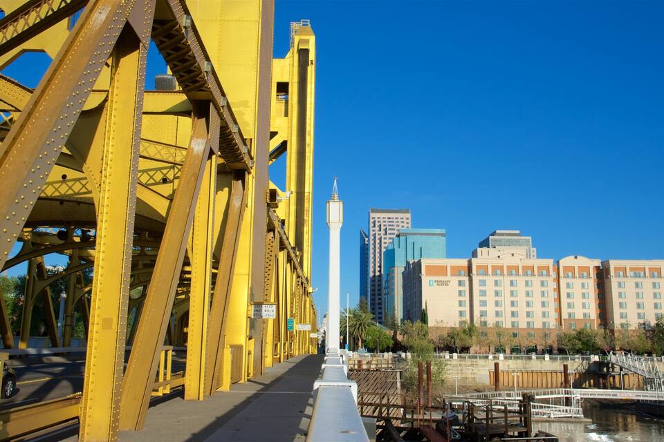 A yellow bridge with a cityscape in the background.