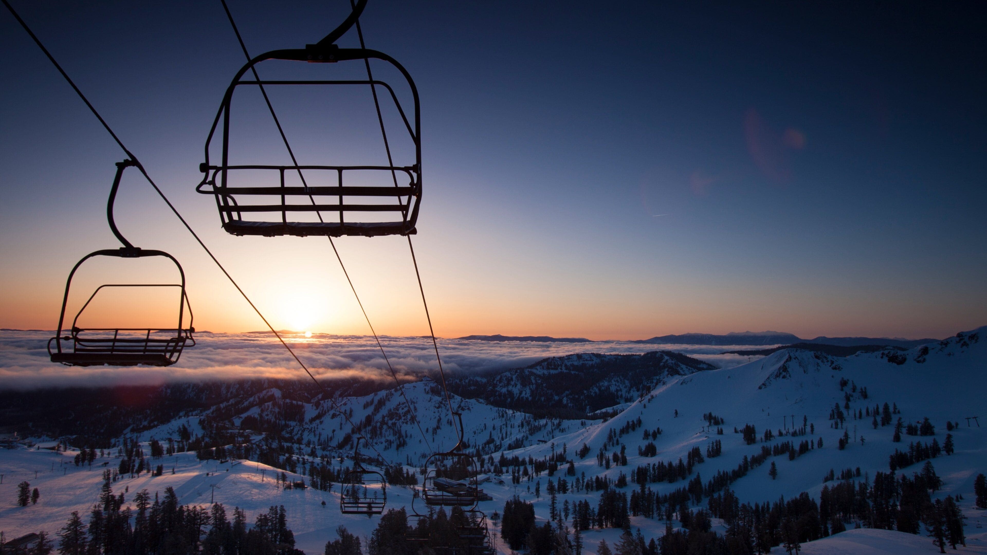 Palisades Tahoe featuring a gondola, snow and a sunset