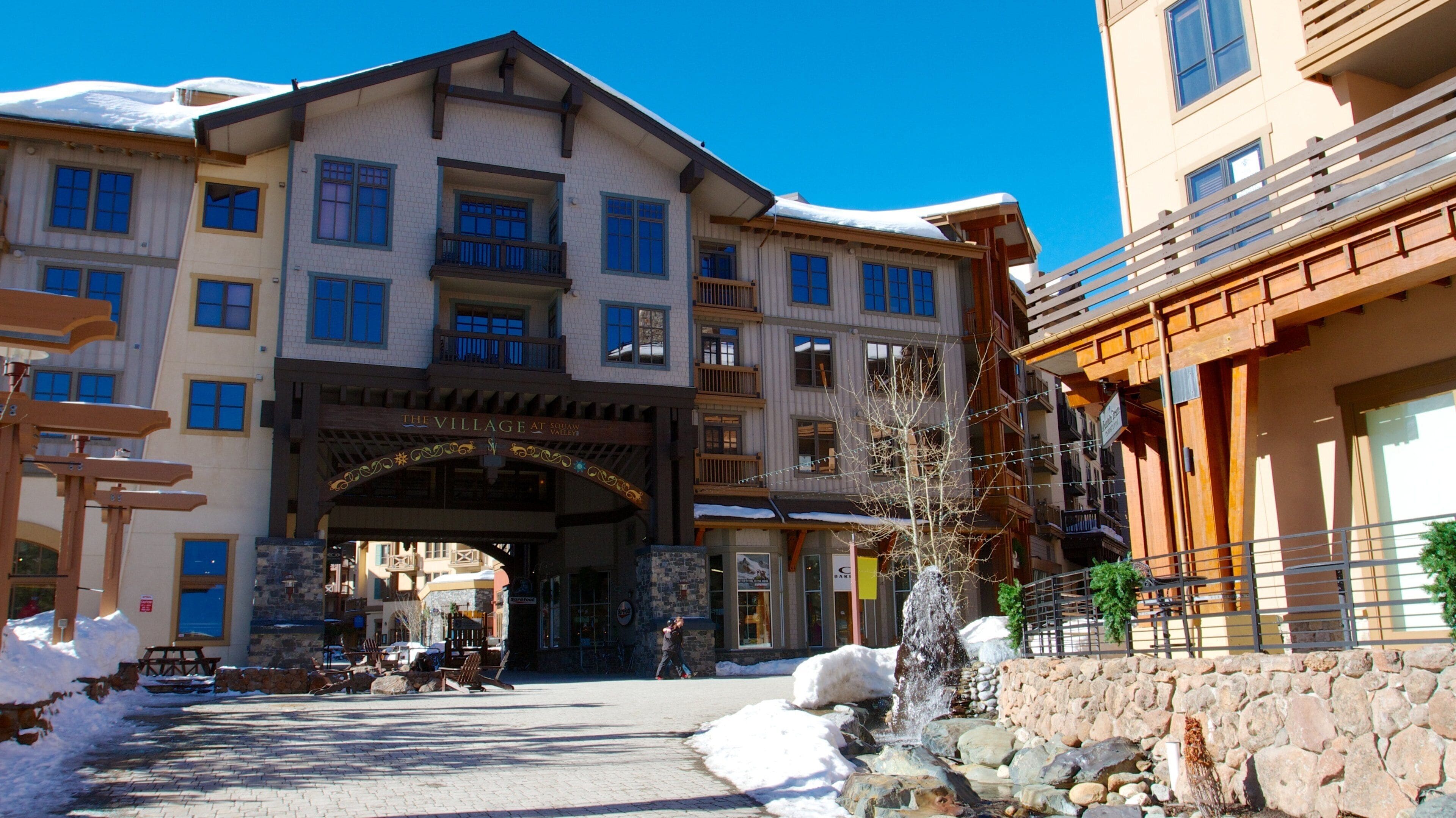 Ein schneebedecktes Gebäude mit einem Schild, auf dem "The Village at Squaw Valley" steht.