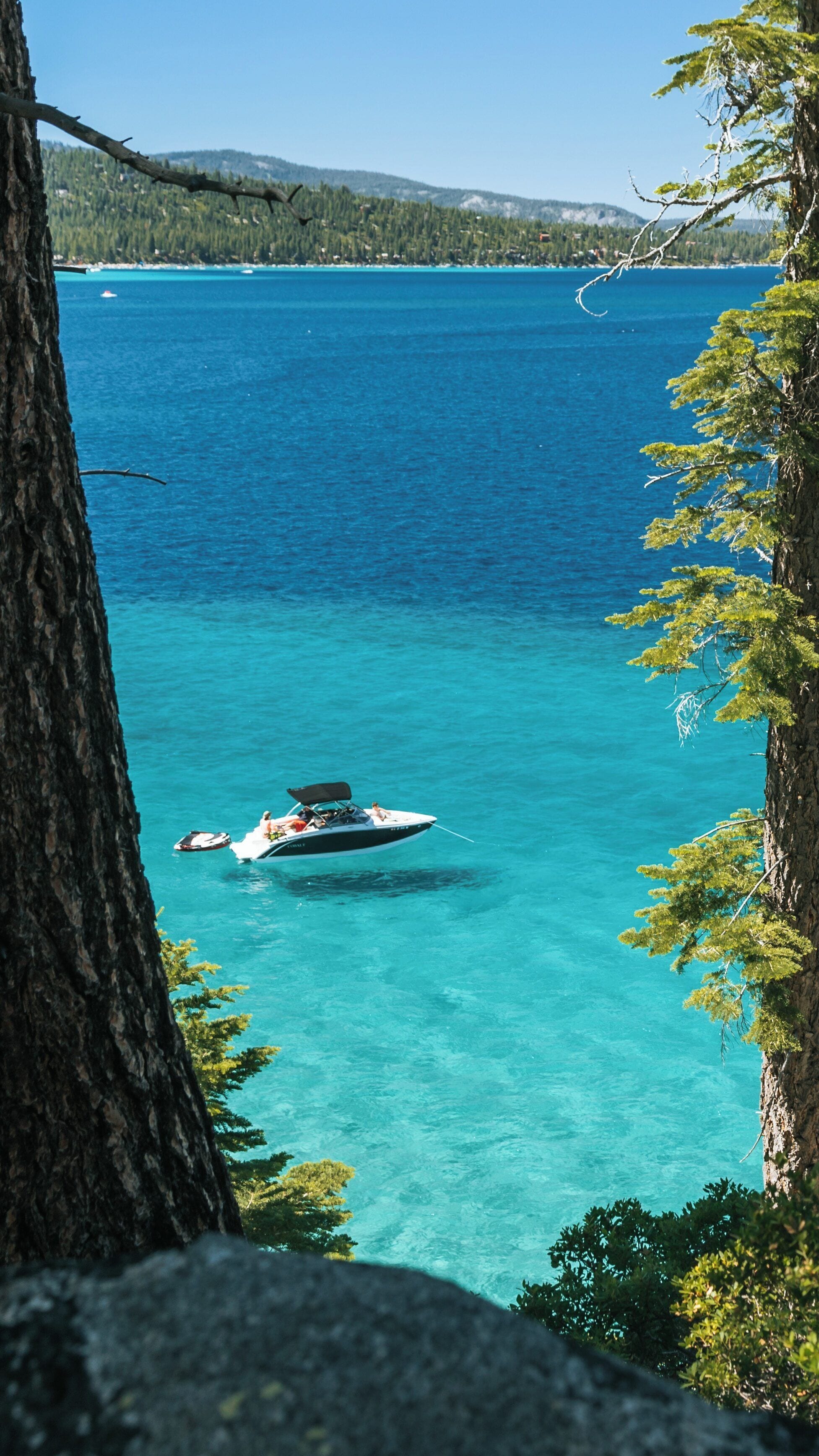 Scenic view of clear blue waters and a boat at D. L. Bliss State Park in South Lake Tahoe, California, capturing a perfect summer day