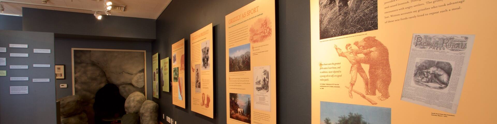 A museum exhibit with educational posters on grizzly bears and agriculture.