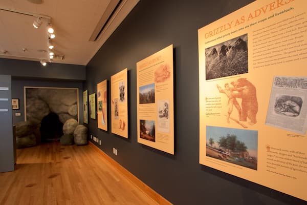 A museum exhibit with educational posters on grizzly bears and agriculture.