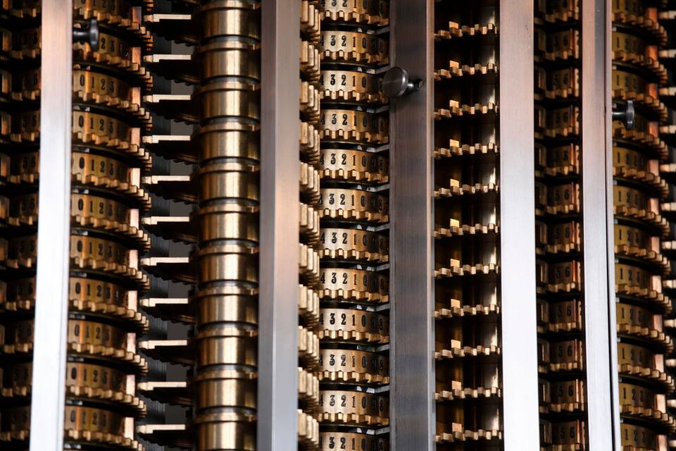 A close-up of a mechanical device with numerous dials and numbers, likely part of a control panel or machinery.