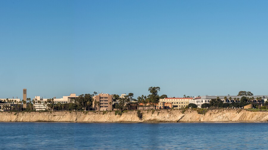 Santa Barbara, United States - Febriary 16, 2018: Panorama Skyline of University California Santa Barbara seen from across Goleta Bay off Goleta Pier. Blue water and sky. Henley Gate on the right.