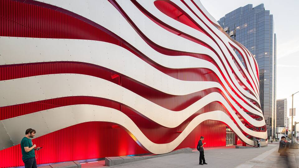 Ein modernes Gebäude mit einer roten und weißen, wellenförmigen Fassade.