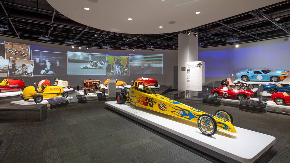 Eine Museumsausstellung mit Oldtimer- und modernen Rennwagen.