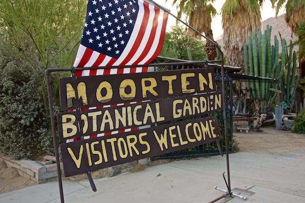 Skilt for Mooren Botanisk Have med et amerikansk flag.