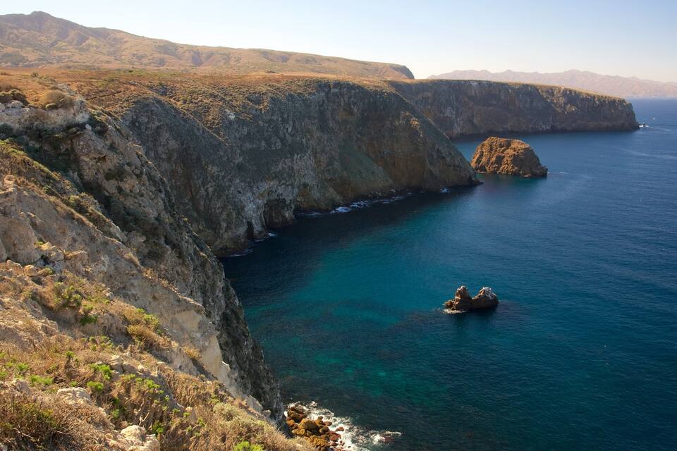 Paisaje costero con acantilados y un mar azul cristalino.