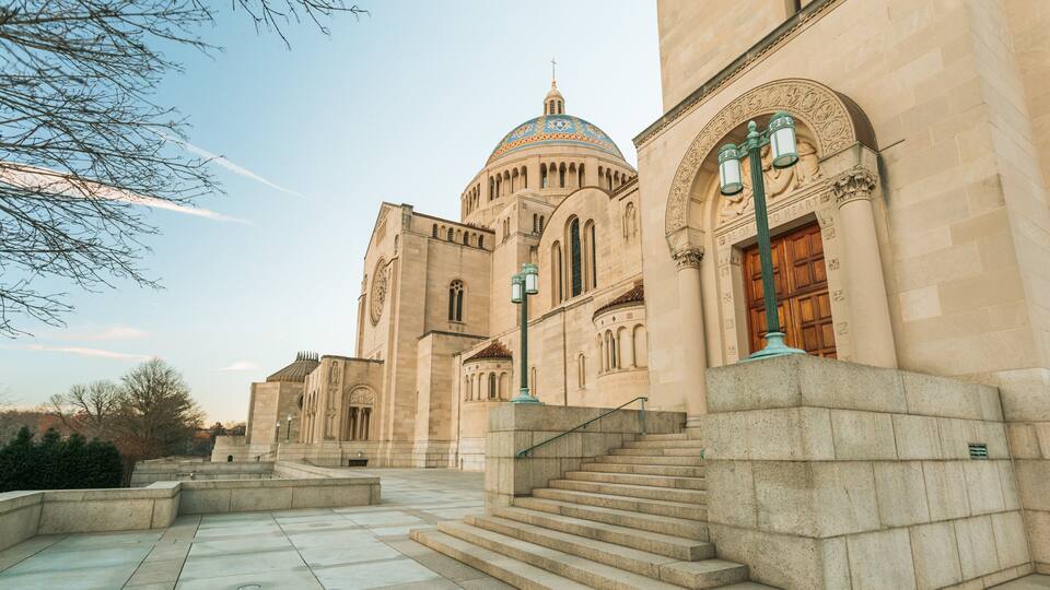 A large, historic building with a prominent dome and arched windows.