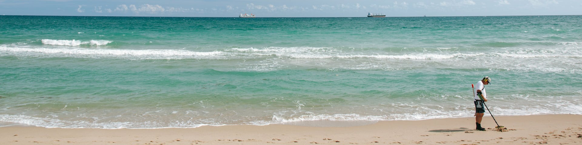 Hugh Taylor Birch State Park featuring a beach and general coastal views as well as an individual male