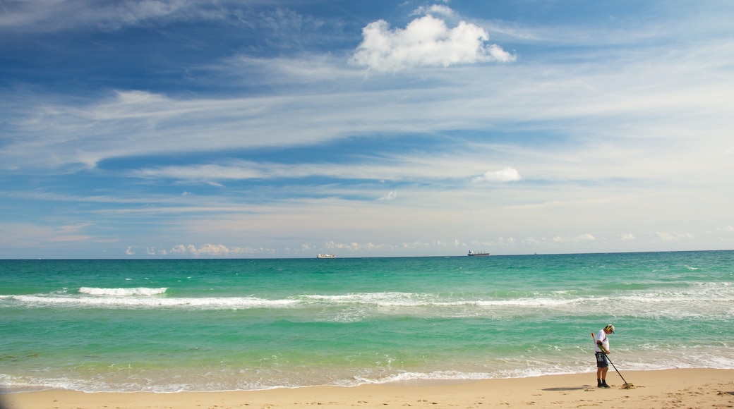 Hugh Taylor Birch State Park featuring a sandy beach and landscape views as well as an individual male