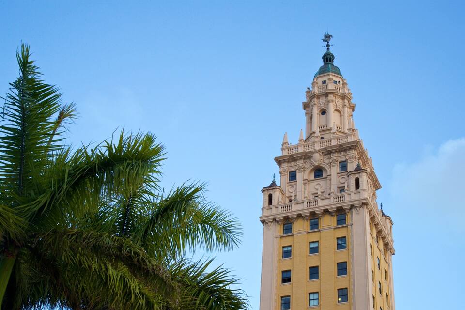 A tall building with ornate architectural details and a green dome.