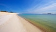 Een strand met helder ondiep water en een zandstrand.