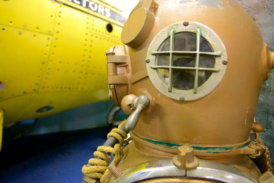 A vintage yellow submarine with a round porthole and a rope handle.