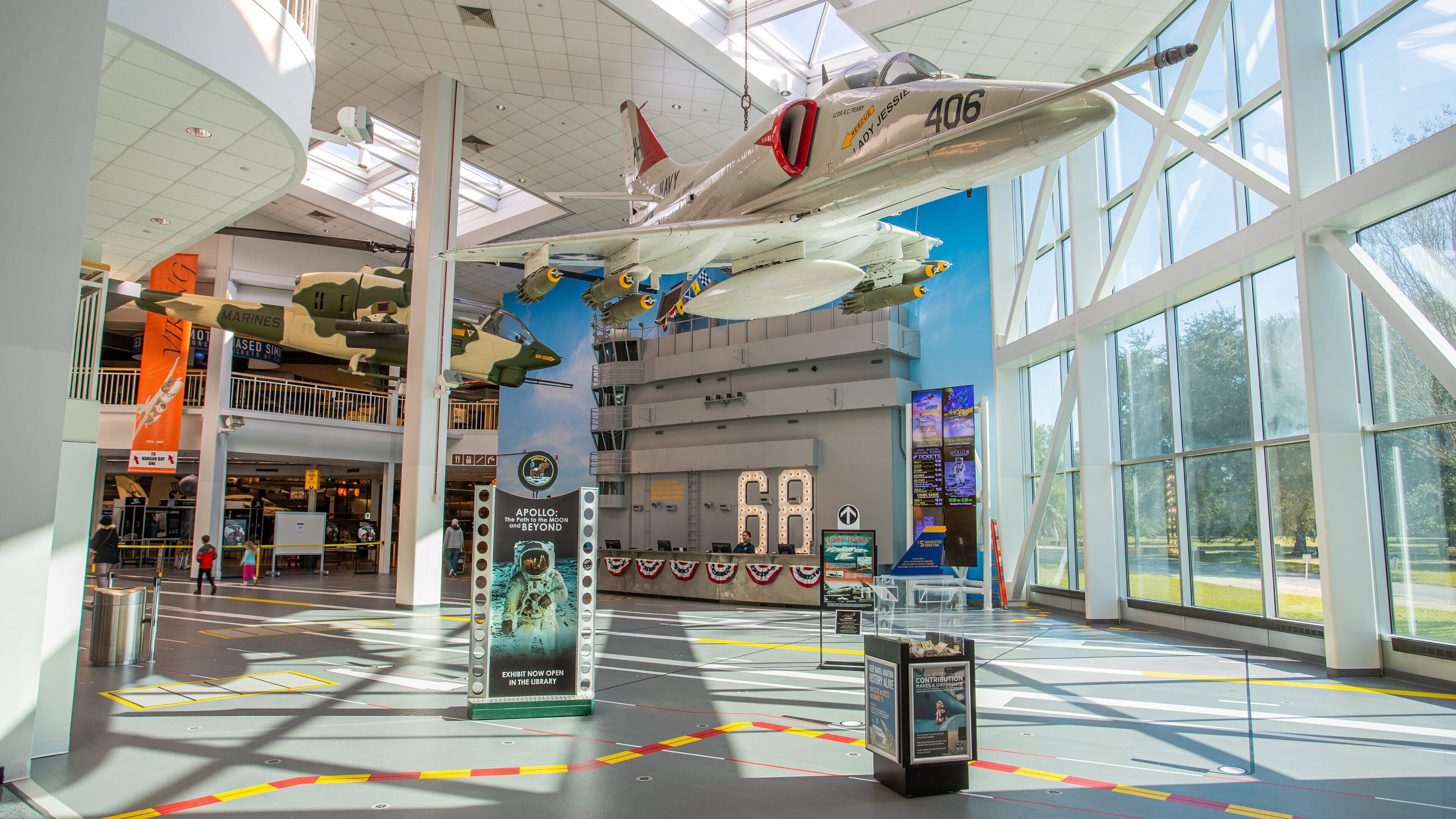 Un museo con un grande aereo sospeso dal soffitto, un cartello con il numero '68' ed esposizioni sull'esplorazione spaziale.