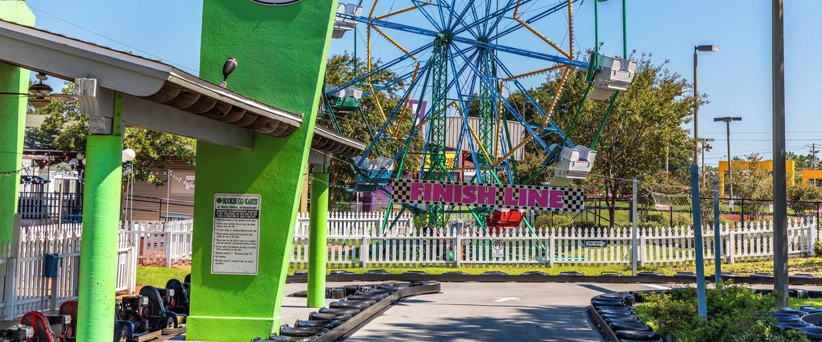 A Ferris wheel at a Fun City amusement park with a green entrance and a 'Finish Line' sign.