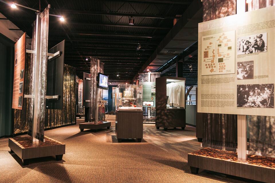 An indoor exhibit with informational displays, a central table, and a large poster on the right.