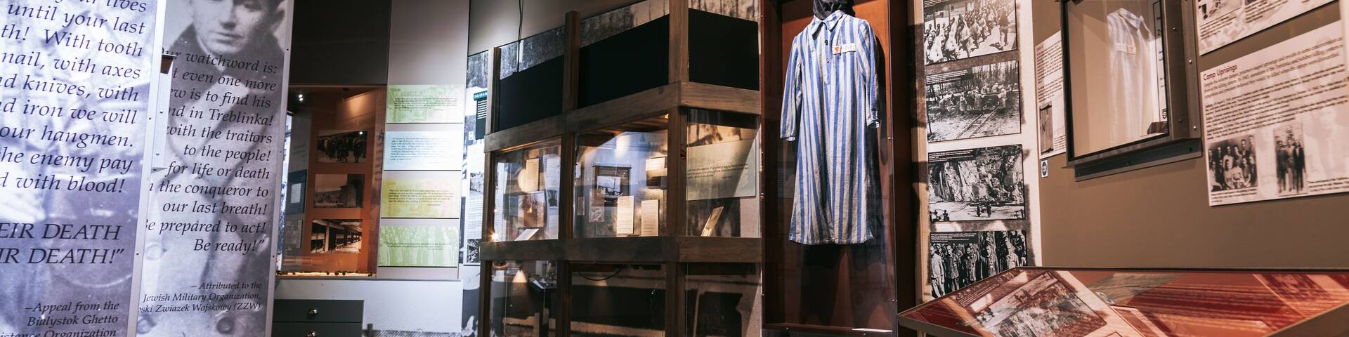An exhibition with historical displays, including a mannequin in a striped shirt and various informational panels.