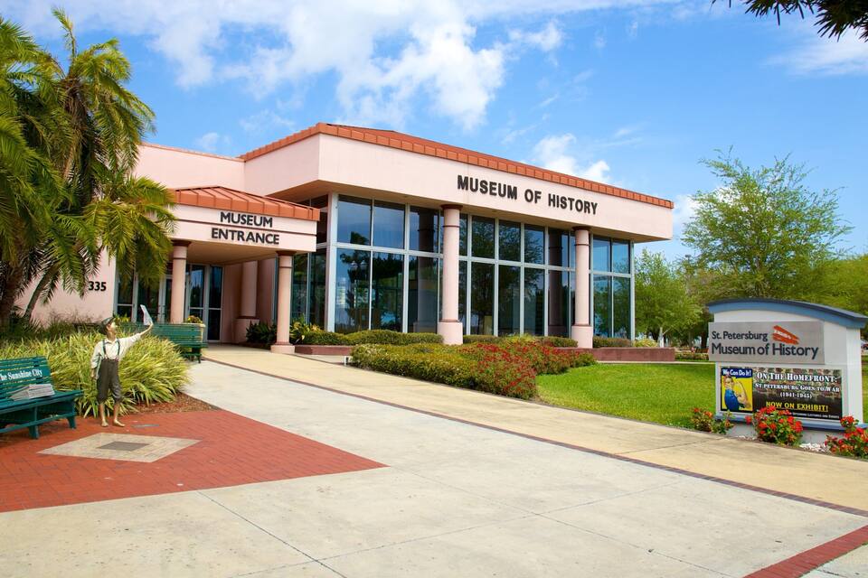 The Museum of History building with a clear entrance sign, a green bench, and a signboard with historical information.