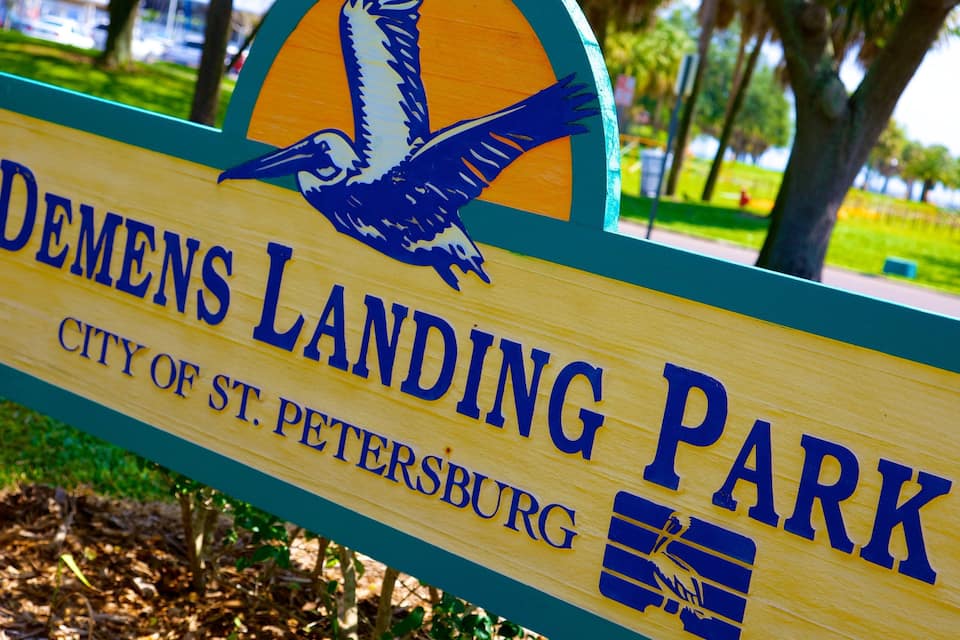 Señal de madera para el Parque Demens Landing con una ilustración de un pájaro y el texto 'Ciudad de St. Petersburg'.