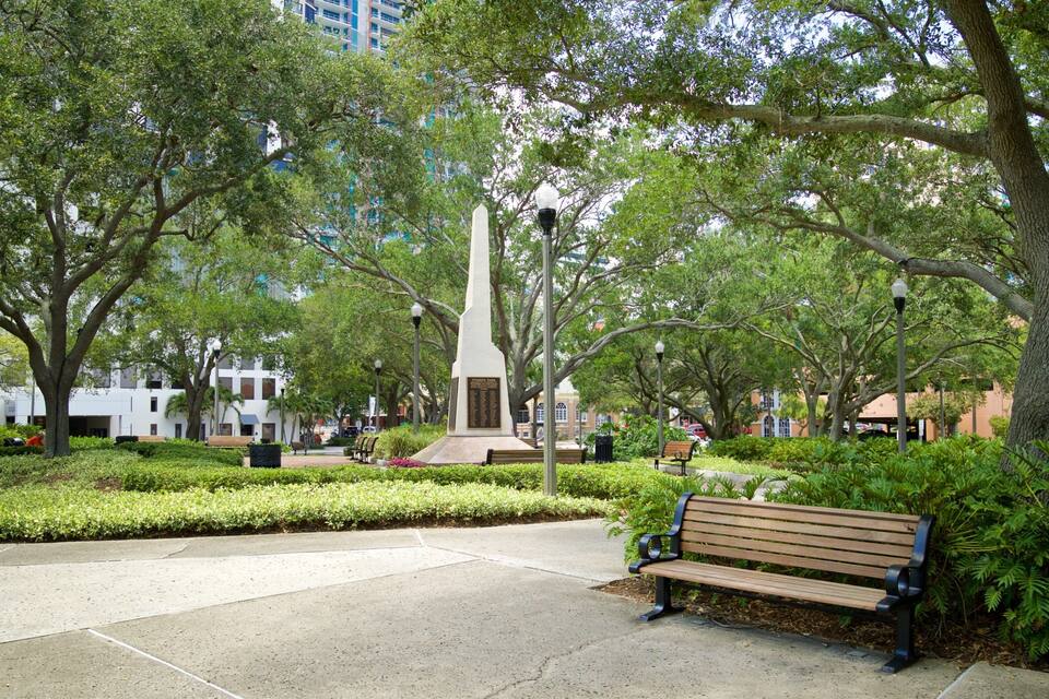 Een park met een monument, banken en bomen.